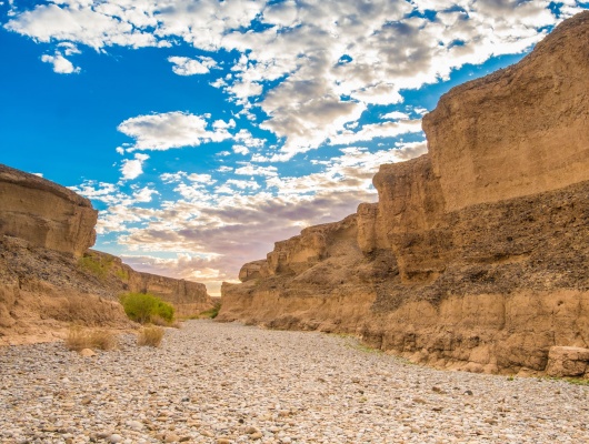 Sesriem Canyon, Sossusvlei, Namib-Naukluft National Park, Namibia. A natural canyon carved by the Tsauchab river in the local sedimentary rock, about a kilometre (0.6 mile) long and up to 30 meters (100 feet) deep. The name Sesriem is Afrikaans and means "six belts",given by settlers on the Dorsland Trek who had to attach together six belts (made of oryx hides) in order to reach buckets down into the canyon to scoop up water. The Sesriem Canyon is only two metres (6.5 feet) wide in some places, and has a portion that permanently contains water, which many animals use.